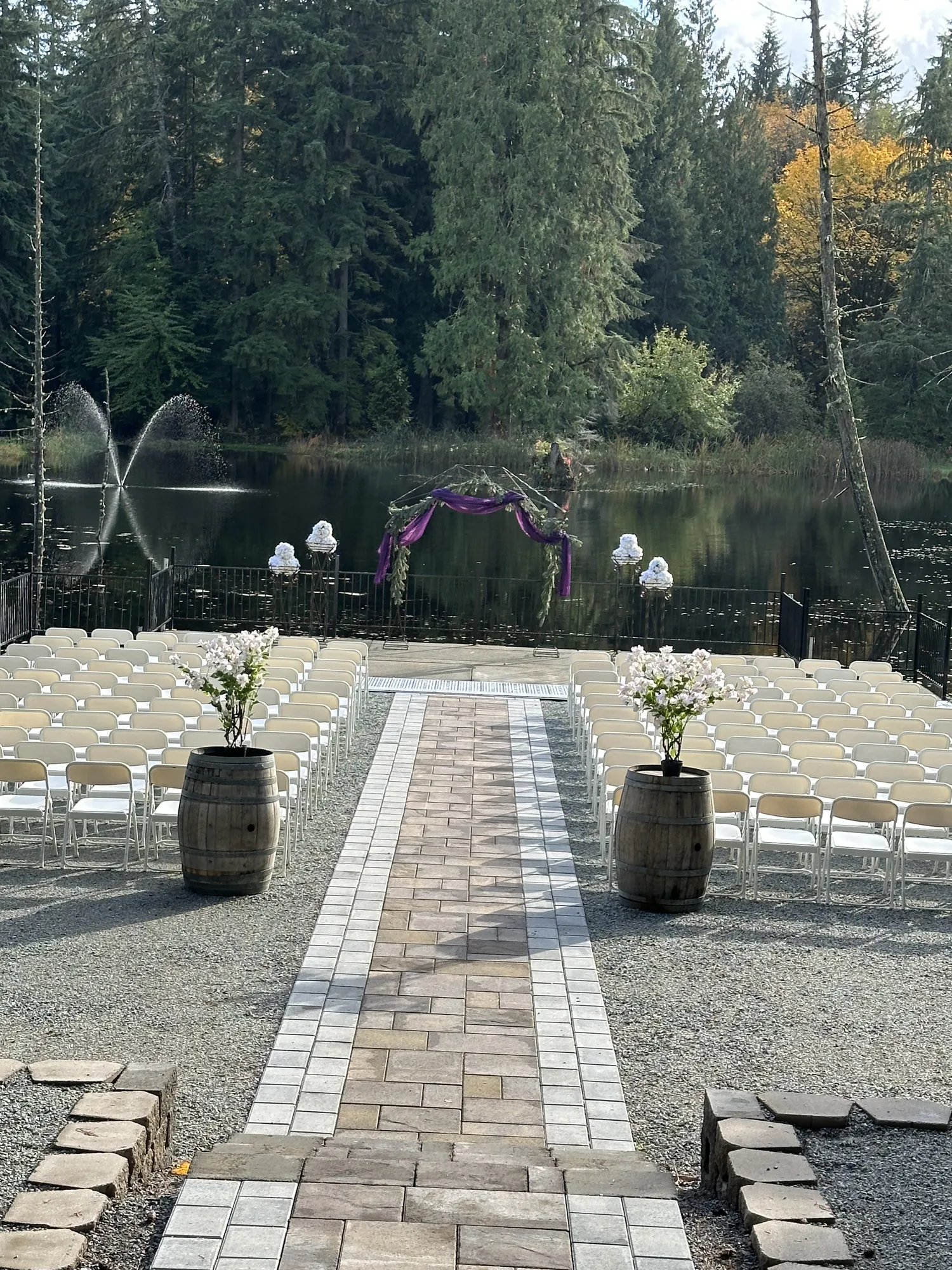 Paver aisle leading to the lakeside ceremony arch, with fountains on the lake